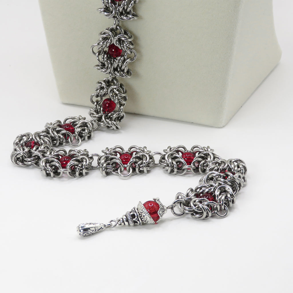 Close up of a Stainless Steel handmade chainmail necklace with red glass beads 