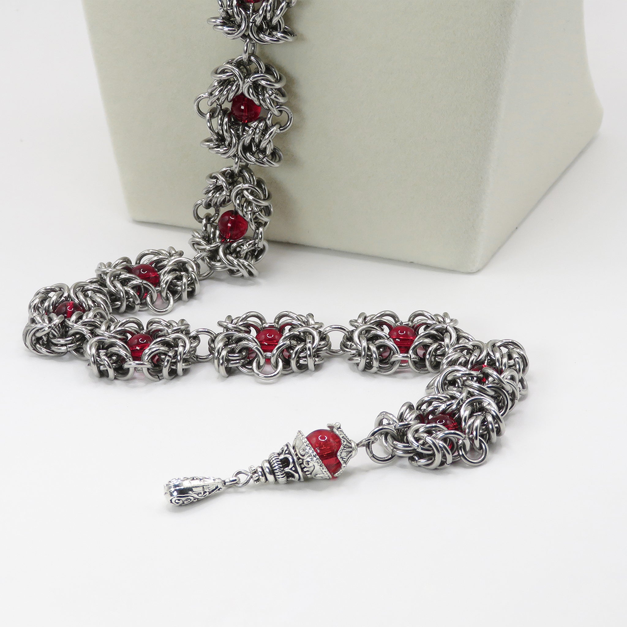 Close up of a Stainless Steel handmade chainmail necklace with red glass beads 