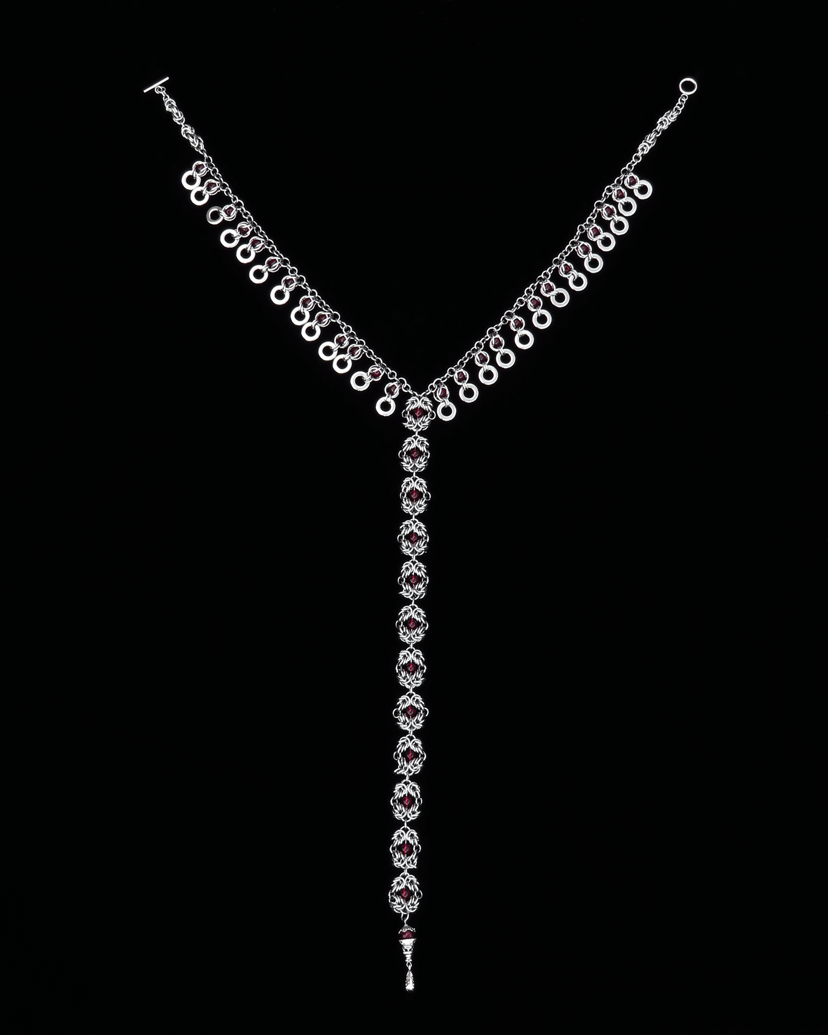 Stainless Steel handmade chainmail necklace with red glass beads on a black background